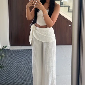 Vita byxor med knytning - Säljer ett par snygga vita byxor med knytning i midjan, använda endast 1 kväll. Perfekta för sommaren och kan stylas både uppklätt och avslappnat. Materialet är lätt och luftigt, skriv privat för fler bilder❤️