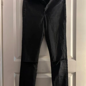 Svarta högmidjade jeggings från &Denim - Säljer ett par svarta högmidjade jeggings från &Denim. De är i storlek 27/30 och har hål på knäna, inga fläckar eller hål annars. 