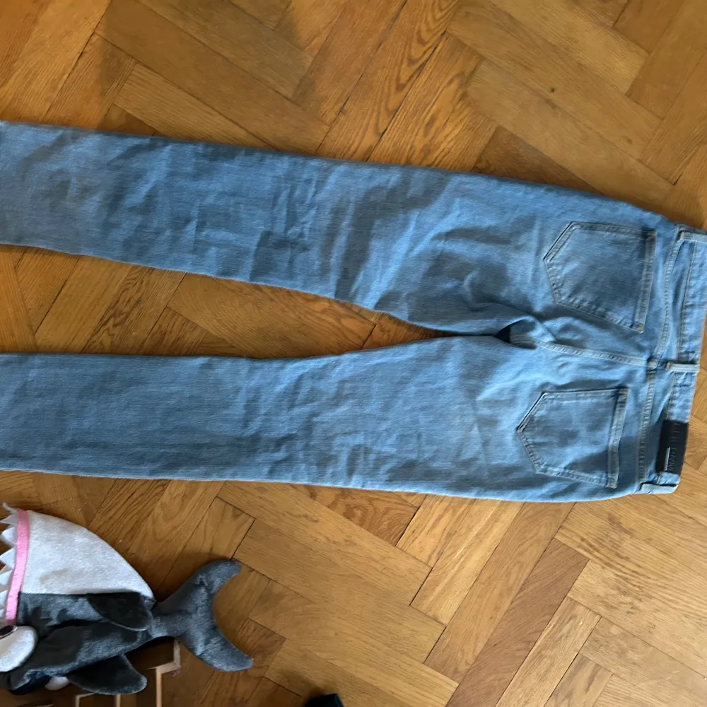 Ett par ljusblå jeans från BLK DNM. Jeansen har en klassisk femficksdesign och är tillverkade i denim. De har en dragkedja och knapp framtill.. Jeans & Byxor.