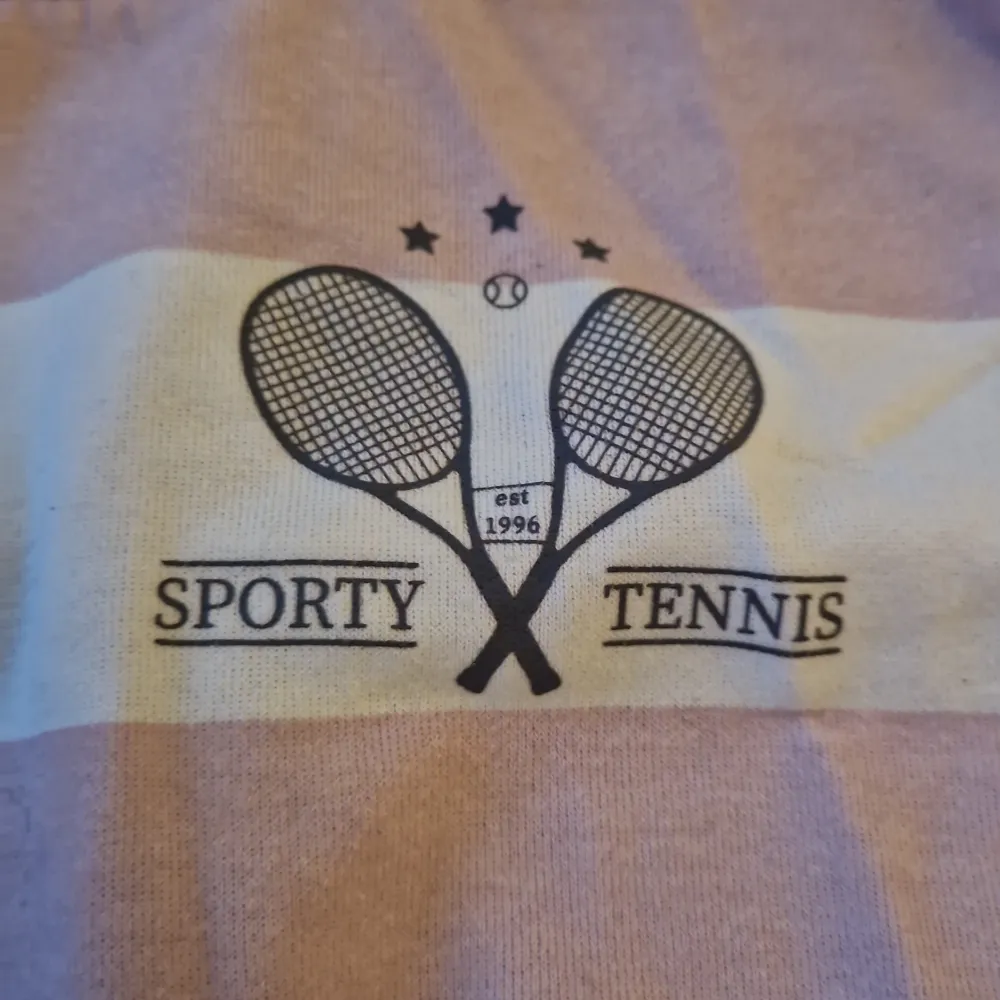 Säljer en superfin randig tröja från H&M i storlek 146/152. Tröjan är rosa och vit med ett tryck av två tennisracketar och texten 'Sporty Tennis' på bröstet. Den är långärmad och har ribbade muddar vid ärmslut och nederkant. Perfekt för en sportig look eller bara för att chilla i! 💖. Tröjor & Koftor.