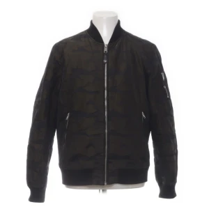 Snygg bomberjacka från Jofama Måns Zelmerlöw stl M - Super snygg bomberjacka från Jofama i samarbete med Måns Zelmerlöw i stl M. Diskret kamouflage mönstrad (brun/svart), mellan tjockt fodrad så perfekt för klassisk svensk höst/vinter. Stl M i mkt fint skick. Fler bilder kan fås vid efterfrågan 