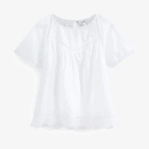 Vit blus  - Vit söt somrig blus med olika detaljer, köpt utomlands, i nyskick. 