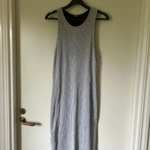Grå ribbad klänning  - Grå midilång ribbad klänning i riktigt mjukt och skönt tyg. Svart underkjol så den inte är genomskinlig. Använd ett fåtal gånger.