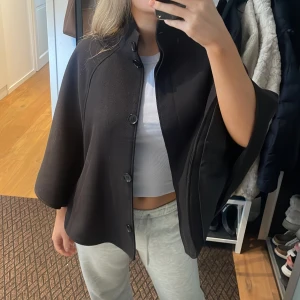 Poncho  - Svart poncho från HM  Inga defekter Knappar framtill, inget skärp 