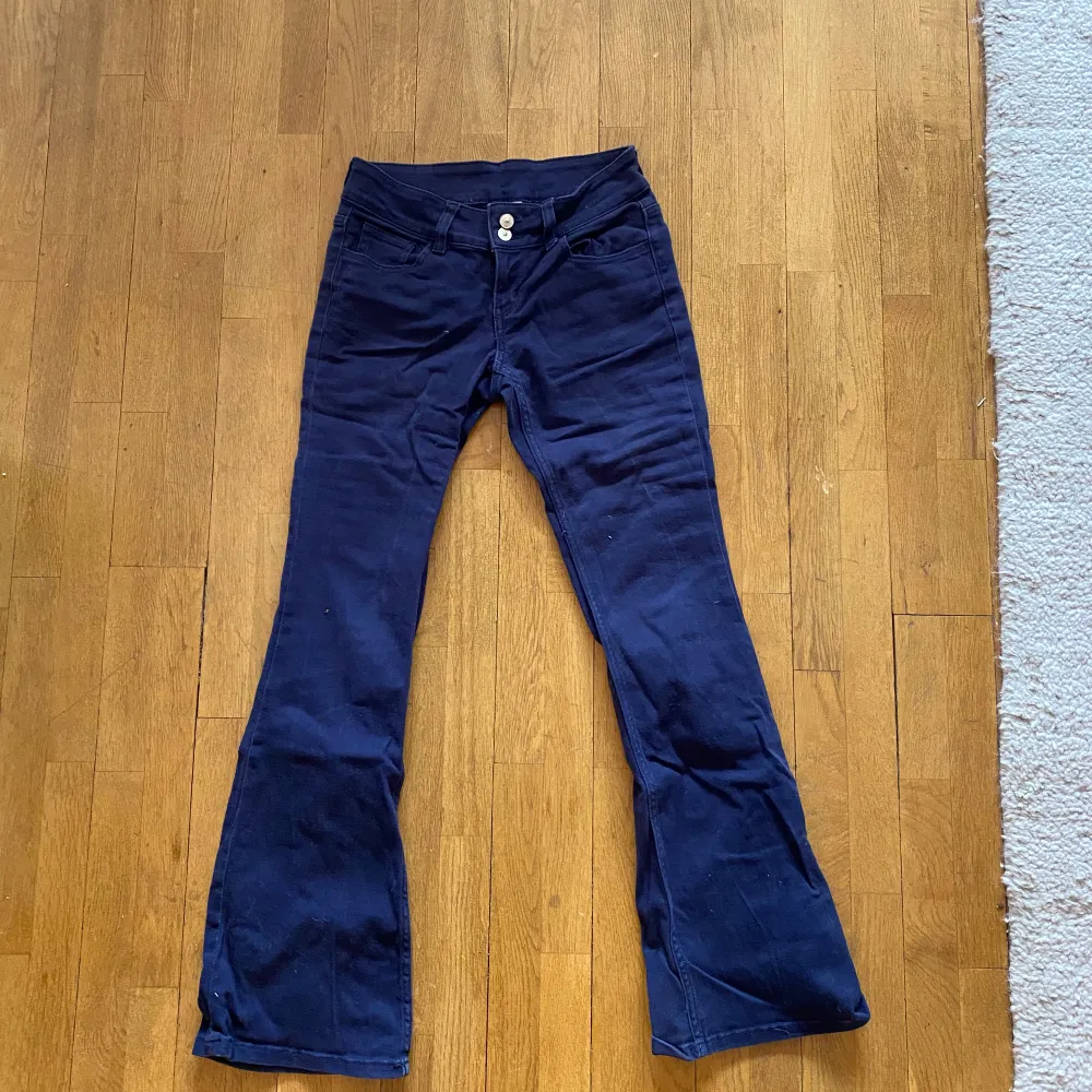 Säljer mina mörkblå lågmidjade Bootcut jeans från HM, snygga fickor baktill och dubbelknäppta där fram! Enbart använda ett par gånger (lite små i storleken). Jeans & Byxor.