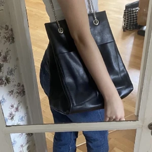 Svart Väska NA-KD - Den är helt slut överallt!! Säljer då den inte används. Inga defekter alls. Får plats med mycket. Ett fack inuti med dragkedja. Äkta läder, därför lite dyrare pris. Kommer inte gå med på bud om billigare. Orginalpris: 500.