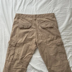 urban classics cargo byxor - W34, midjemåttet är 41cm & innerbener 80cm, baggy fit. köpte från en secondhand butik, använd ett fåtal gånger men i mycket bra skick. går även att skjustera bensluten. pris går att diskuteras. 