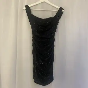 Säljer min fina glittriga klänning med offshoulder ärmar ifrån asos!! En kort tajt klänning som passar perfekt till fest, endast använd 1 gång💕💕nypriset låg på 1000kr!