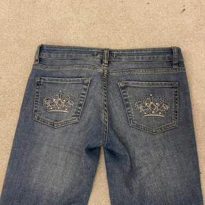 Ett par jättefina jeans med kronor på bakfickorna. Jag har sytt på lite extra längd längst ner på benen men det är nästan samma färg. Midjemåttet är 72cm och innerbenslängden är 82cm💕
