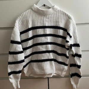 Randig tröja - Randig virkad tröja från lager 157. Storlek M. Använd fåtal gånger och är i mycket bra skick. Vit och mörkblå/svart. 