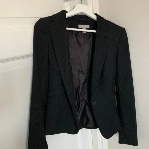 Svart Kavaj  - Säljer denna skitsnygga svarta kavajen från H&M som är använd max 3 ggr 🤍 supersnygg att ha till tex fest eller finare arrangemang 😊 den har lite axelvadd i sig! Skriv priv vid fler frågor/bilder!! 