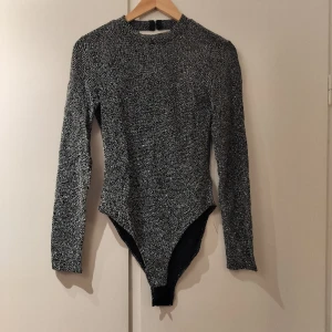 Glittrig svart/grå/silver body med öppen rygg - Superfin och glittrig body, perfekt för party eller typ en Taylor Swift-konsert. Storlek S men relativt stretchig. Snygg detalj med öppen rygg.