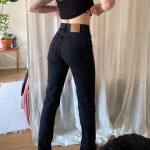 Svarta Levis jeans i modellen 70s High Slim Straight. Storleken är Waist 23 Lenght 31. Urtvättade svarta med uppklipps slits på insida ben/fot. Längden på byxbenet mätt från skrevet: 79-80 cm