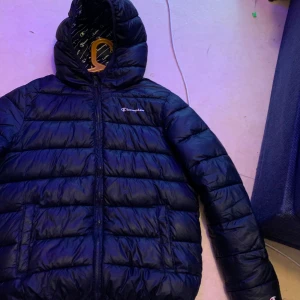 Marin blå Champion jacka - Storlek M och är lite använd. Den har ett litet rivmärke på ärmen men är lagat så de knappt syns