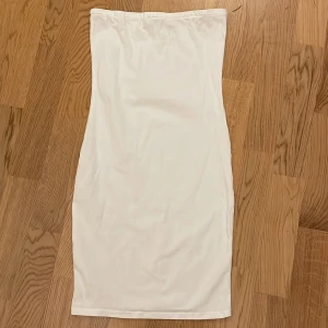 Tubklänning - En vit, Tubklänning med silikonrämsa längst upp för att den ska hålla sig uppe extra mycket. Bra skick. Typ oanvänd. Storlek Xs från Nakd. 