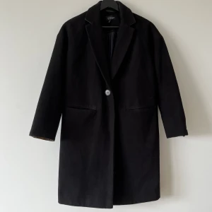 Svart kappa - En svart kappa från topshop i fint skick utan noppror någonstans. Fin grön färg under kragen och vid ärmsluten