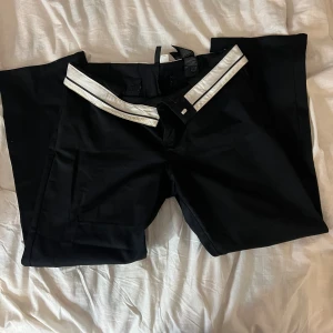 Nervikbara kostymbyxor - Kostymbyxor med nervikbar midja. Låg i midjan när man viker ner dem och annars mellan/hög midja. Rak i modellen. Storlek 42 från h&m.