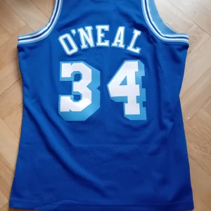 Blå NBA "Shaq" O'Neal Lakers baskettröja - Säljer en blå NBA Shaquille O'Neal Lakers baskettröja. Tröjan är i mycket bra skick och är i storlek L. Nypris är 3200kr. Säljer den för 800kr. Tröjan kan hämtas i Malmö eller fraktas(man betalar frakten själv). Skriv gärna om du har frågor!