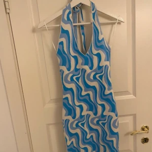 Halterneck klänning - Halterneck klänning från GinaTricot som är blå och vit mönstrad. Har lite små skavanker, (det största syns på bild tre)