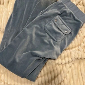 Juciy couture  - Ett par juicy couture byxor i färgen dammig blå. Snöret fattas och det finns fläck längst ner på byxorna, men går lätt bort med fläckborttagning. I övrigt- fint skick
