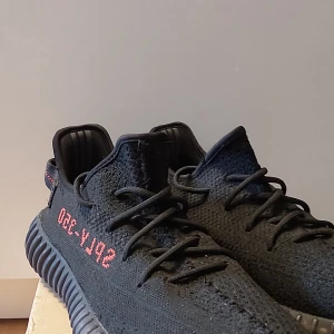 Yeezy Boost v2 black and red - Tjena! Säljer mina skor nu när jag växt ur dem och tycker det är lite synd för de är verkligen skit snygga. Skicket på de är okej men inga trådar eller så som stickor ut utan finns lite repor på sidan.  Kvitto finns om så önskas!