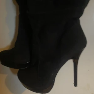 Höga boots klackar i färgen svart - Det är ett par svarta höga boots med klackar. De är lite smuts på men de kan man lätt ta bort med t.ex handen.