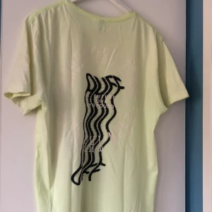 Oversized t-shirt - Neongul/grön t-shirt 💛Färgen plockas inte upp bra på kamera, den är färgstarkare i verkligheten. Stort tryck på ryggen, och mindre tryck på bröstet . Den är i använt men bra skick. Den har lite fläckar som jag ska tvätta bort 😌