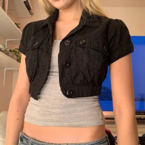 Bolero - Svart bolero med fickor på 