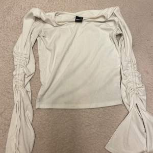 En jätte fin vit tröja från Gina Tricot storlek S. På varje arm finns det en slits som är öppen, som man även kan dra åt och knyta till en rosett. Jätte fin tröja 