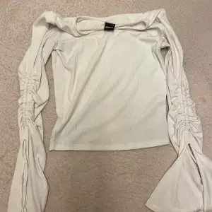 En jätte fin vit tröja från Gina Tricot storlek S. På varje arm finns det en slits som är öppen, som man även kan dra åt och knyta till en rosett. Jätte fin tröja 