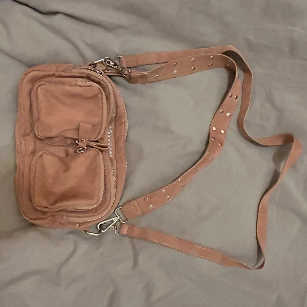 Handväska från Gina tricot, aldrig använd. Färgen är nude smutsrosa med silver detaljer. . Väskor.