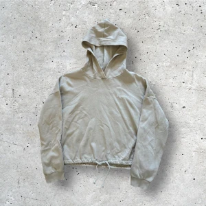 Beige croppad hoodie - En croppad beige luvtröja från Gina Tricot i storlek M. Snörning nere i hemmen. I fint skick. 