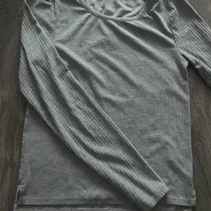 Långärmad grå tröja som har ett litet hack på båda nedre sidorna💓