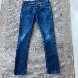 Levi’s lågmidjade jeans - Köpte då jag trodde att det var herr jeans men visade sig att det var lågmidjade jeans. Innerbensmåttet är 82 cm och det är väldigt bra skick förutom små slitningar på knäna kan skicka bild vid begäran. Tveka inte att fråga vid funderingar☺️ 