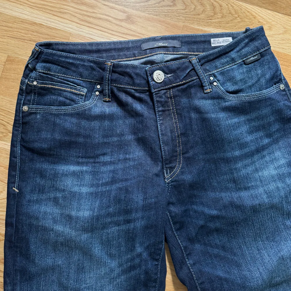 Ett par mörkblå, lågmidjade bootcut jeans från Mavi, Zalando. De heter ”Bella Midrise bootcut”. Väldigt fina i kvaliteten och bra skick förutom lite slitningar vid fötterna (sista bilden). Innerbenslängden 88cm. Ordinariepris 629kr. Jeans & Byxor.