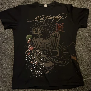 Ed Hardy T-shirt - Fett ball ed Hardy tisha med rhinestones som är köpt på secondhand men kommer inte till så mycket användning, fattas några rhinestones men annars i perfekt skick utan några skador!💯🔥💯🔥 