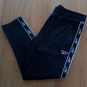 Reebok byxor  - Oanvända svarta byxor från Reebok. Finns även i mörkblå, se annons i min profil.   Rensar ur min garderob från en hel del oanvända kläder🌼 Om du ser något mer i min profil som du gillar så skickar jag med det till dig också!😊 Fler kläder kommer!
