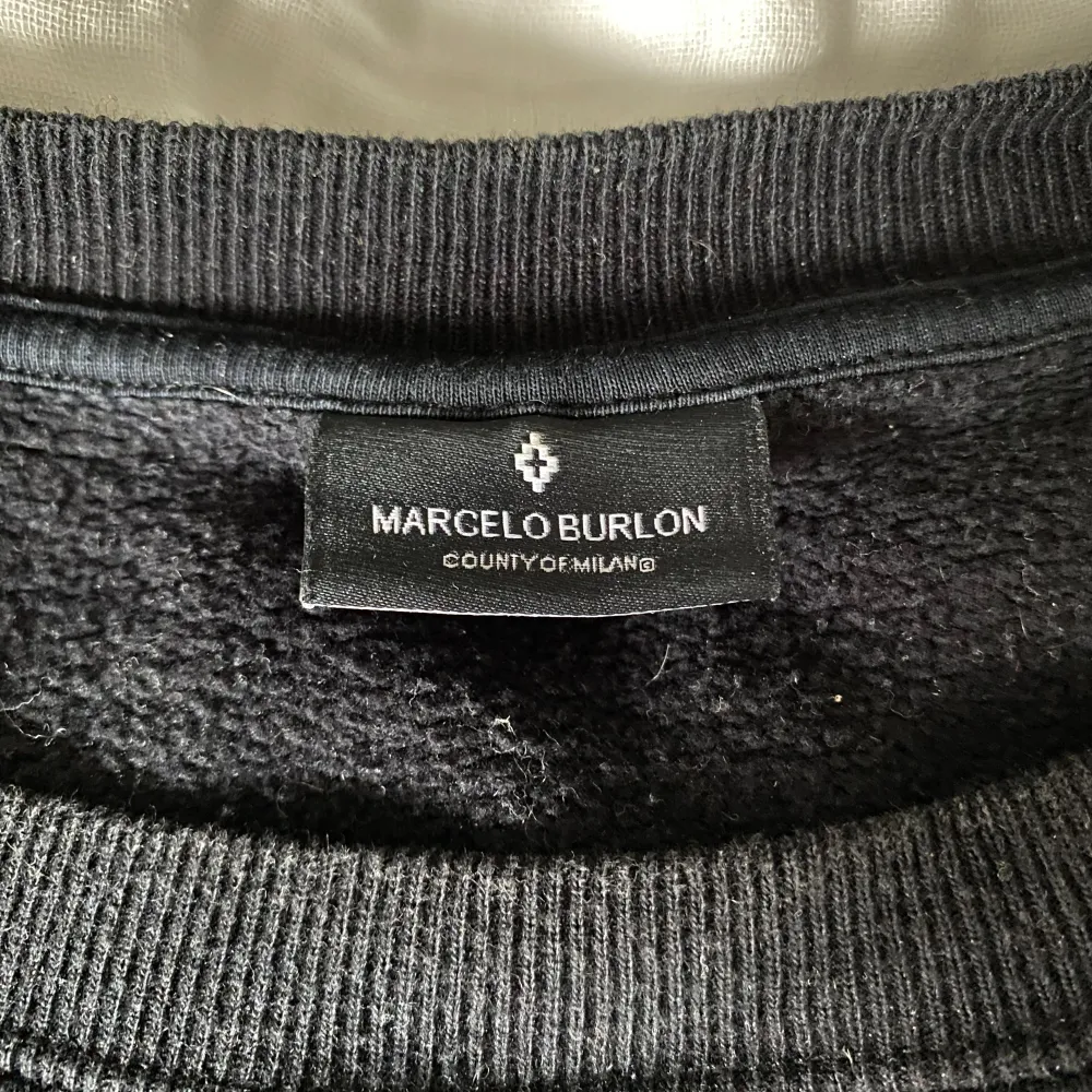 Säljer nu denna fina tjocktröja från Marcelo burlon med ett sjukt fett tryck på. Storleken är M och svart är tröjans färg.. Tröjor & Koftor.