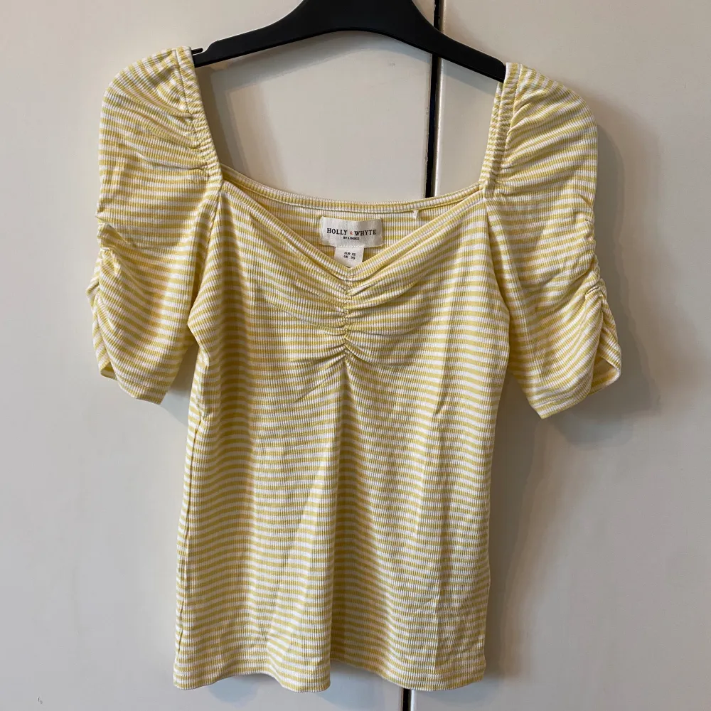 Gullig gul och vit randig sommartopp med scrunch i ribbat materialđ. Passar fint till vardags med ett par jeans eller mer uppklĂ€tt till kjol. đ„°AnvĂ€nd nĂ„gra fĂ„ gĂ„ngerđ€. FrĂ„n Holly & Whyte by Lindex. Passar Xs-Sđ. Puserot.