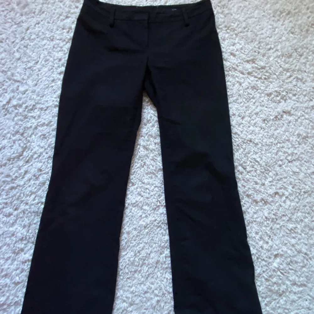 Storlek 38. Svarta kostymbyxor med tunna röda linjer. Lågmidjade och lätt utsvängda💞. Jeans & Byxor.