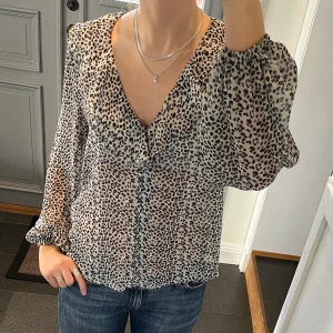 Leopardmönstrad volangblus  - Volangblus med leopardmönster med knappar från New Look. Storlek 36. Knappar i fram. Fint skick. Använd gärna köp nu!