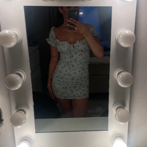 Ljusblå blommig klänning - En jättefin klänning från bikbok, i storlek S, endast använd 1 gång, stretchig