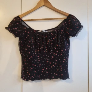 Svart blommig topp - Säljer denna blommiga topp med meshrygg💓 Köpt på plick men den har tyvärr inte kommit till användning💓 Som ny! Säljer för 75kr + frakt, priset kan diskuteras vid snabb affär🫶