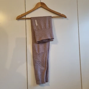 Gymshark thights  - Säljer dessa gymshark tights i en lila/rosa grumlig färg (den är mindre grå i verkligheten). Något använda men i bra skick, det enda är att "K"et i gymshark har skafts lite (se bild)💓 Priset kan diskuteras🫶