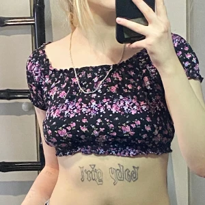 Blommig kort t-shirt - Har inte räknar ut hur den ska vara vid axlarna men den är fin/söt, väldigt gammal men tror inte jag använt den mer än 2 gånger då den är väldigt kort, inga skador och väldigt luftigt material med resorband som håller den på plats.