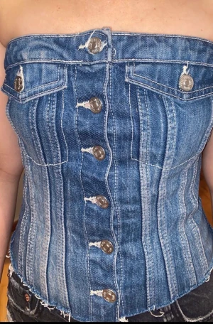 Zara topp - Säljer nu denna fina Zara topp i denim. Väldigt populär och är oftast slutsåld. Väldigt fin till fester och bara vanliga outfits! Nästan helt ny och inte använd utanför mitt eget hem.