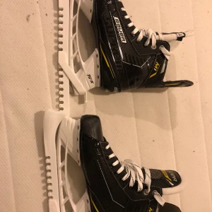 Bauer skridskor - Säljer nu ett par skridskor bauer supreme m1, dem är knappt använda. Tror jag använt dem 7 gånger, bara att åka på skridsko bana ingen hockey.Storlek 38/39. Går så klart att testas på plats.Har två st hockey hjälmar.kostar nya 999 Finns i Helsingborg