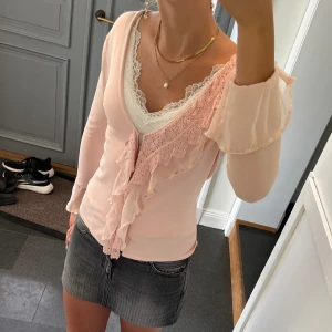 Rosa kofta med volanger  - Beige/rosa trekvartsärmad tröja med spets från H&M. Storlek S. Fint skick. Använd gärna köp nu!