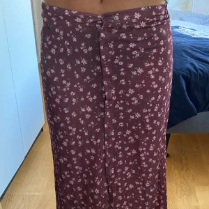 Långkjol - En lång blommig vinröd sommarkjol från pull and bear, fint skick och använd en gång! 💕🍒