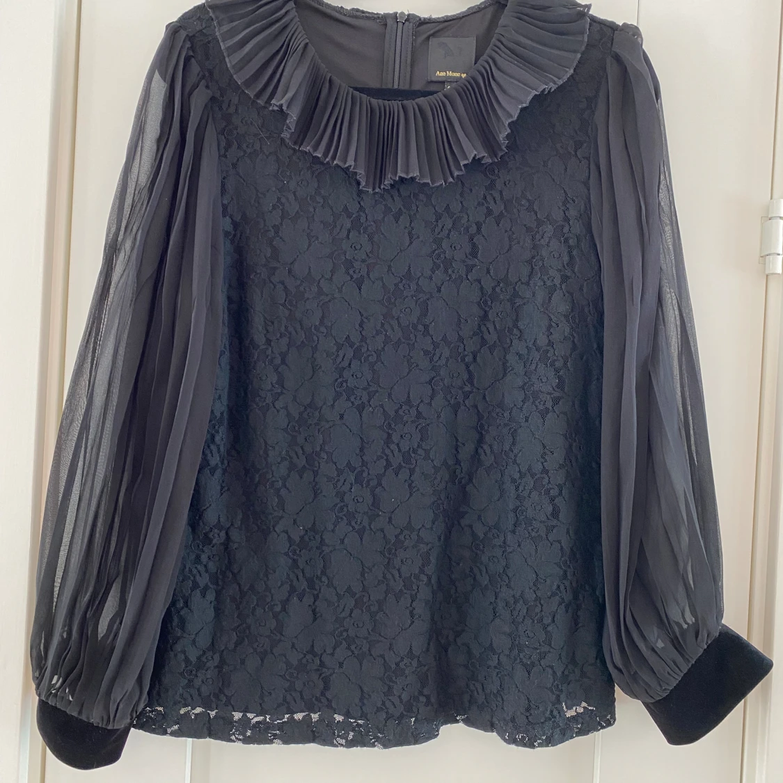 Svart blus med spets och genomskinliga ärmar och krage i strl 40 fr Ane Mone